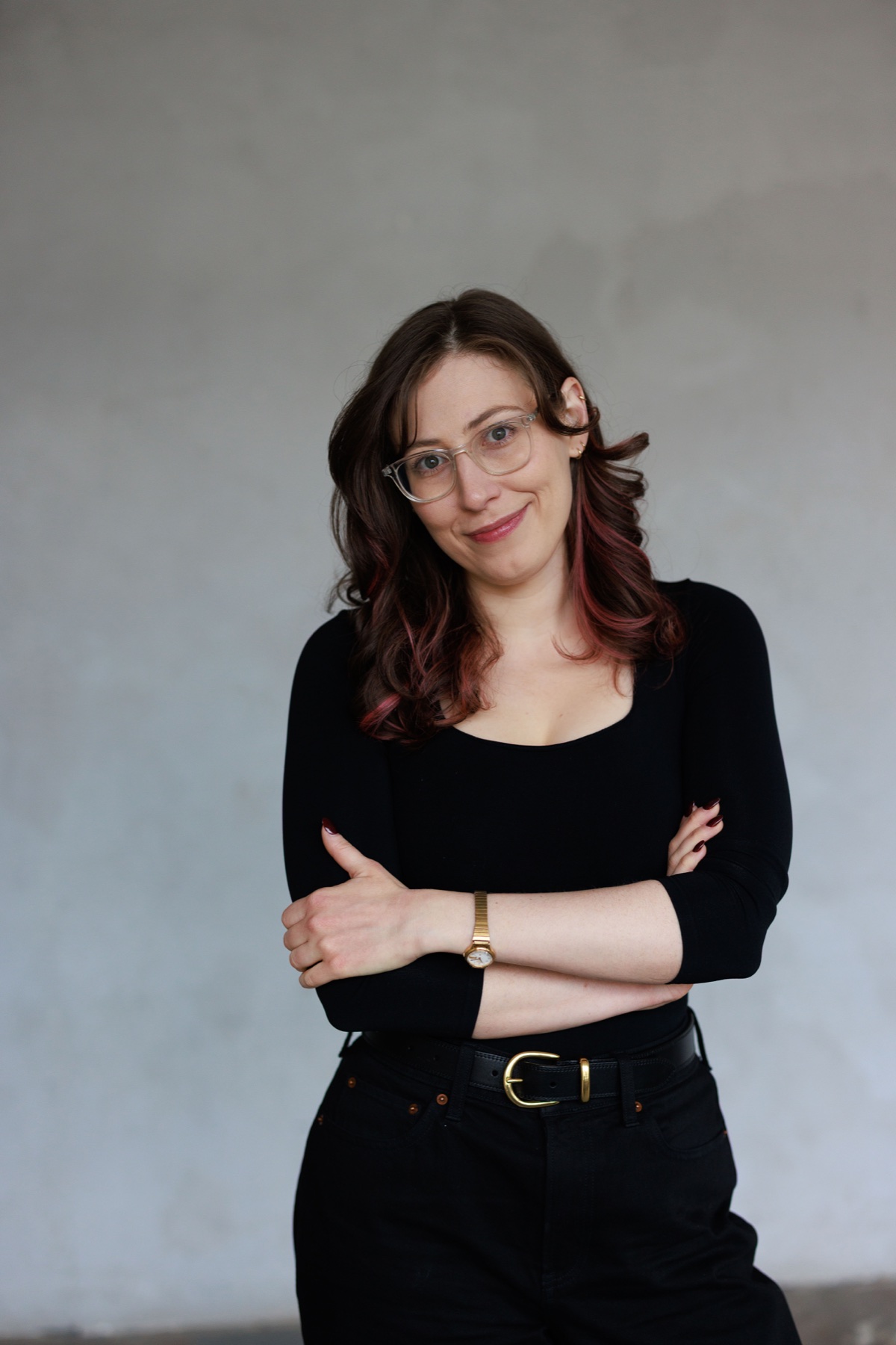 Alberta Devor standing with arms crossed against a light gray background