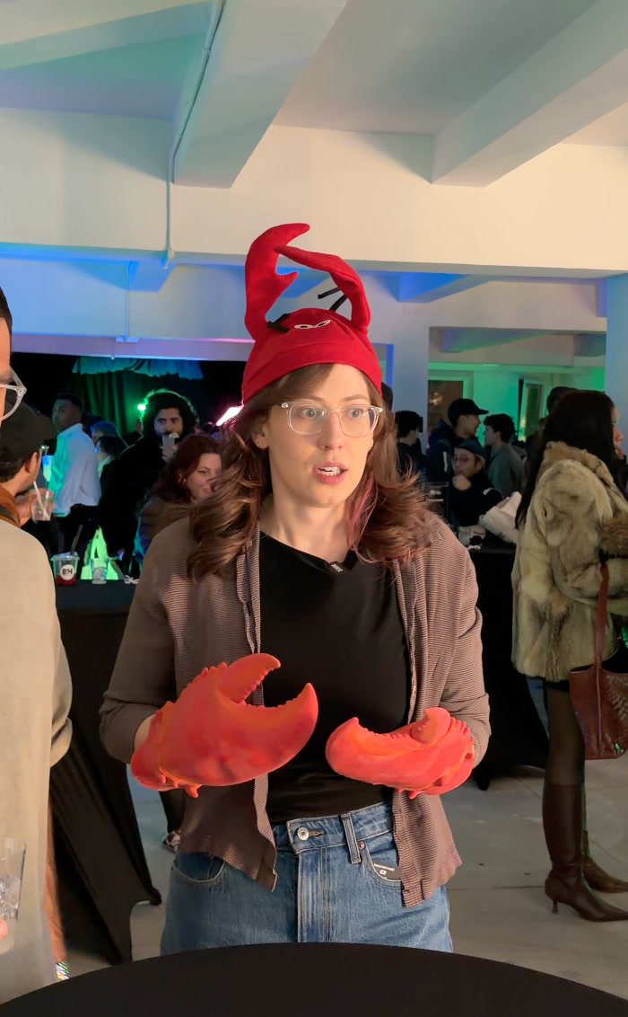 Alberta Tech wearing a red lobster hat and oversized lobster claws at an event